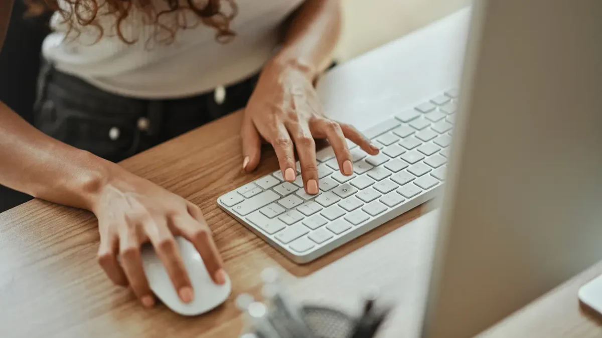 Close-up of a woman using a keyboard and mouse at a desk, symbolising local SEO efforts and digital marketing strategies for small businesses.